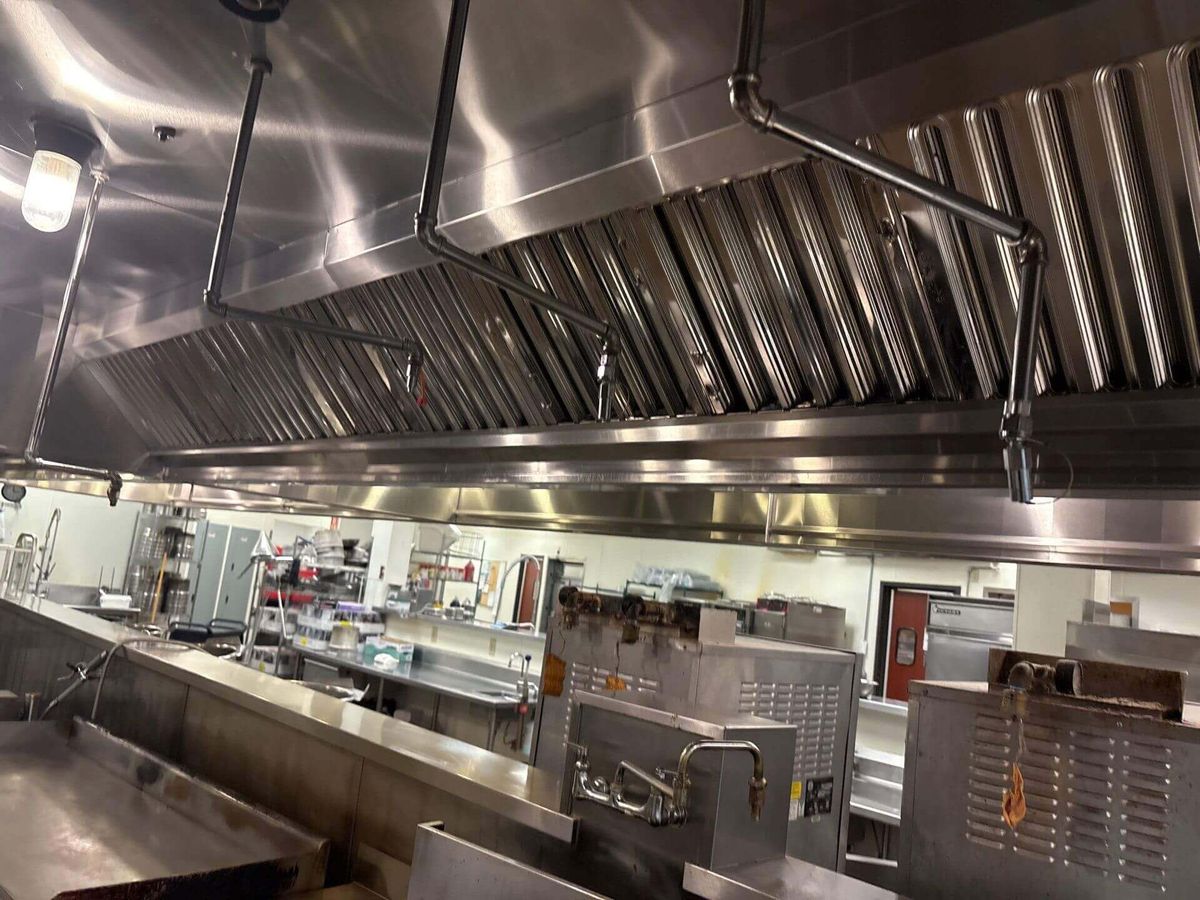 A franchise kitchen line under freshly cleaned hoods