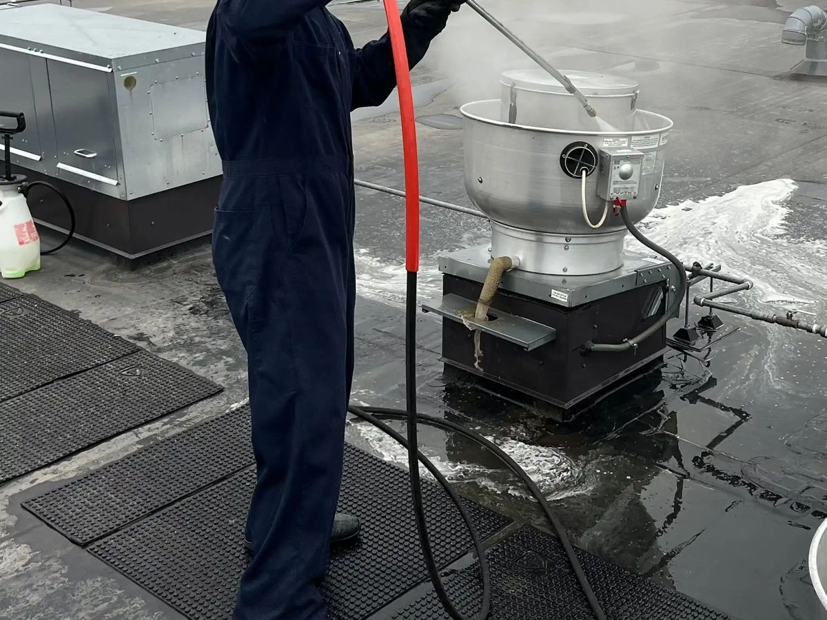 Oregon Hood Cleaning technician cleaning a rooftop exhaust fan