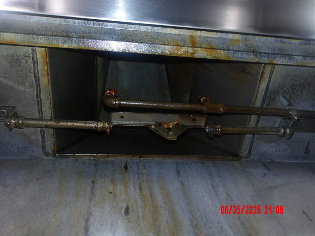 Grease-caked kitchen exhaust duct before cleaning