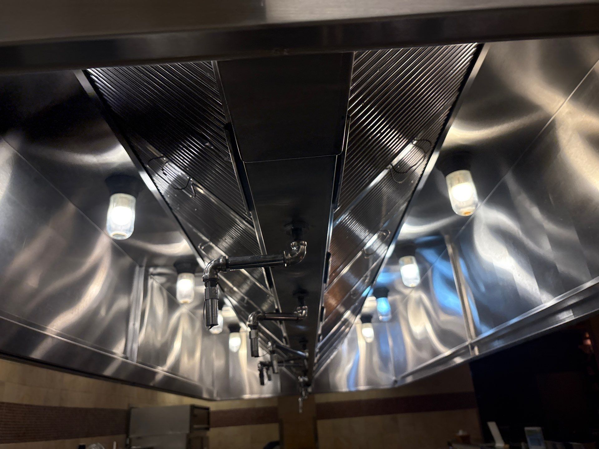 Symmetrical view of a shiny metallic ceiling with lights.